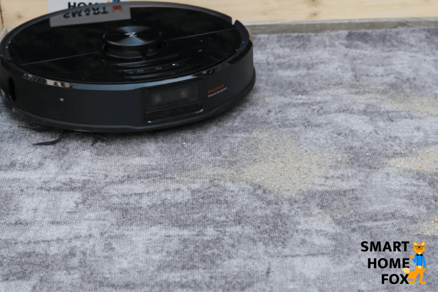 Roborock S6 MaxV saugt Sand auf kurzem Teppich.